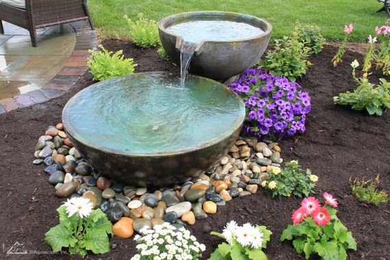 extravagant water pouring down one bowl into another in garden