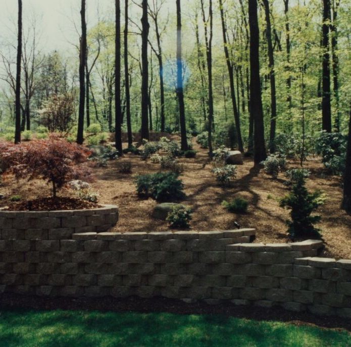 masonry wall in front of woodsy landscape
