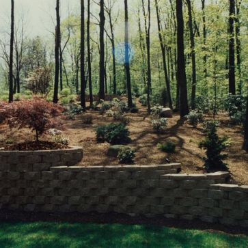 masonry wall in front of woodsy landscape